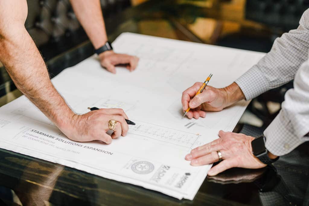 Estimators reviewing and marking up construction drawings