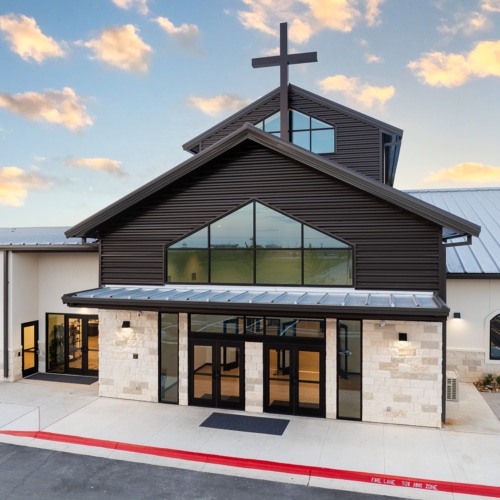 Completed commercial facility with a central entrance and cross by Aday & Associates