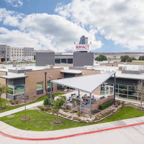 Aerial view of a completed Central Texas commercial office building and parking area.